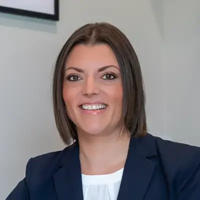 Doctor Anna smiling with a navy blazer in her office